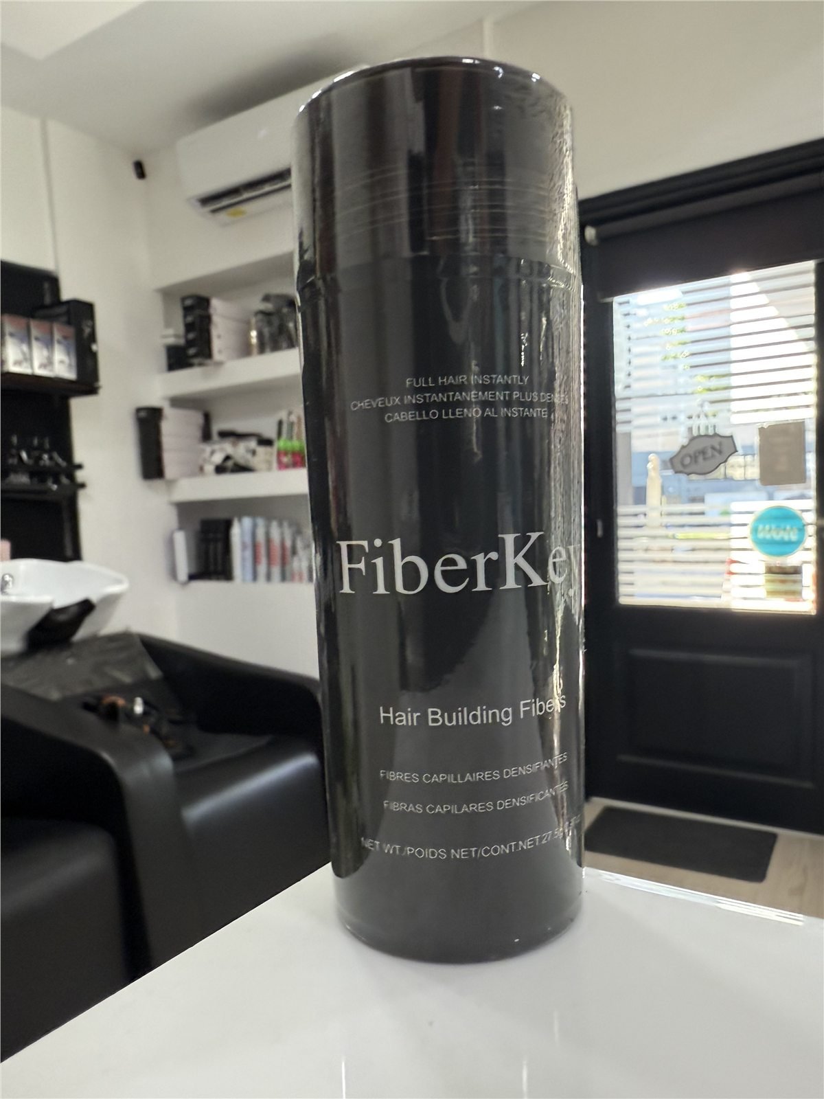 Finished private label hair fiber product displayed inside a barbershop