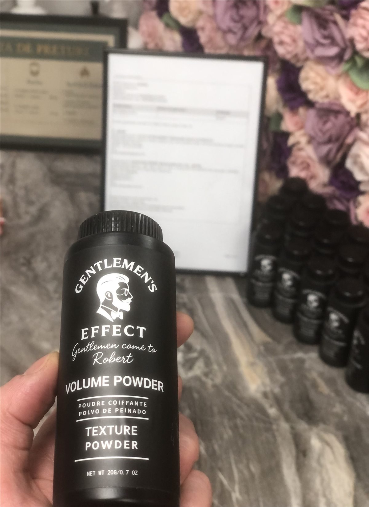 Barbershop owner holding a finished private label volume powder product